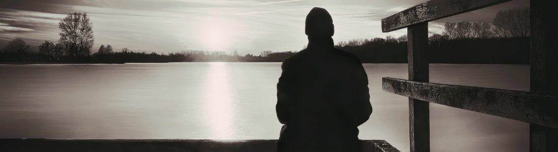 A man sitting on a dock struggling with Emotions and Functional Neurological Disorder symptoms